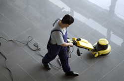 View from above of a man cleaning tile with a tile cleaning machine